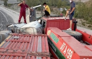 Devrilen kamyon park halindeki arazöz ve otomobile...